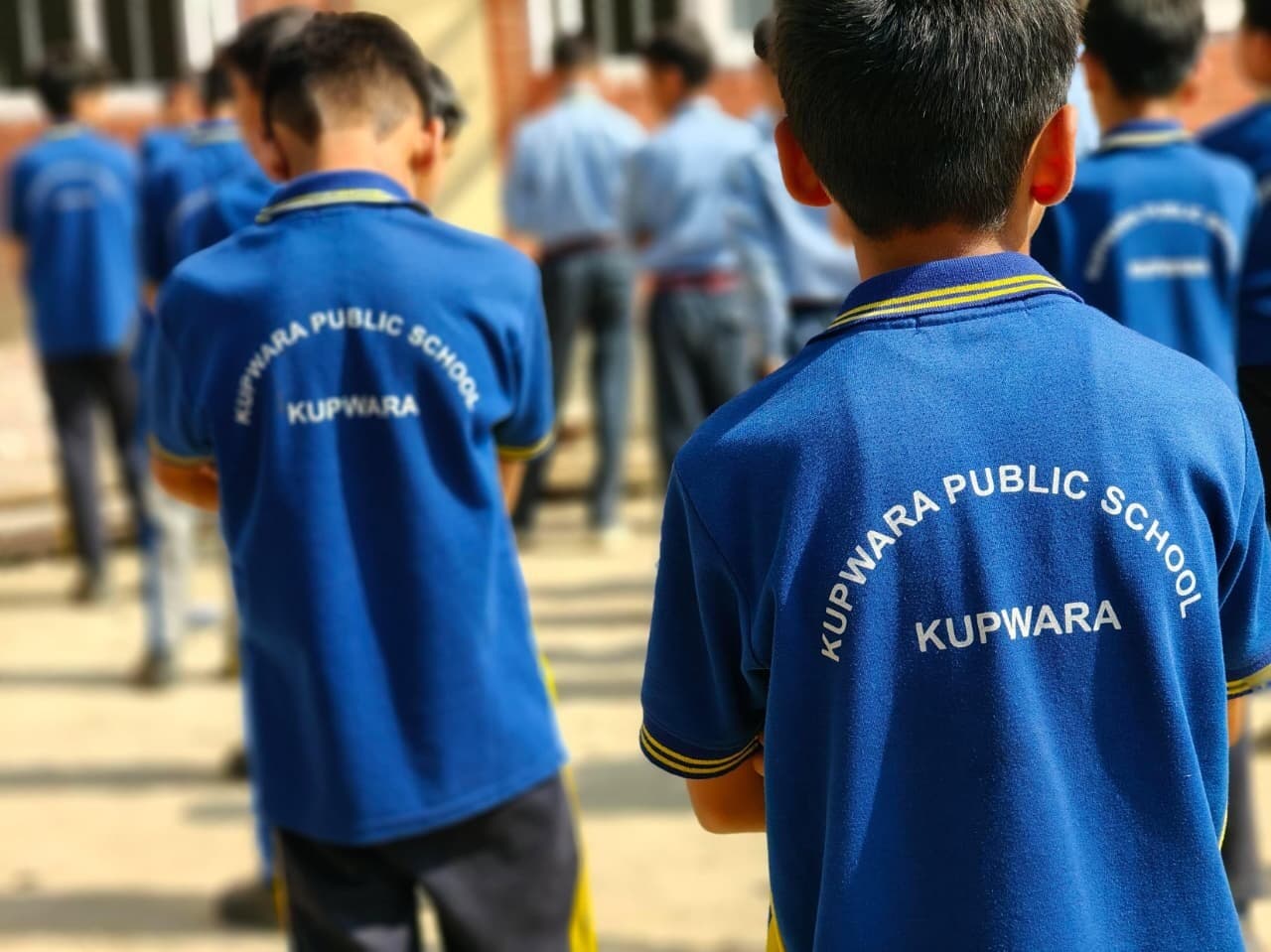 KPS students in the sports-uniform polo, Kupwara Public School printed on the back